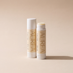 Zwei Aurea Tallow Lip Balm Stifte, einer geöffnet, einer geschlossen