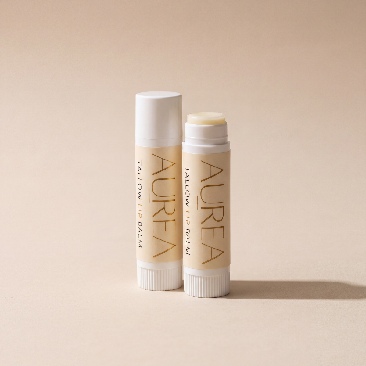 Zwei Aurea Tallow Lip Balm Stifte, einer geöffnet, einer geschlossen